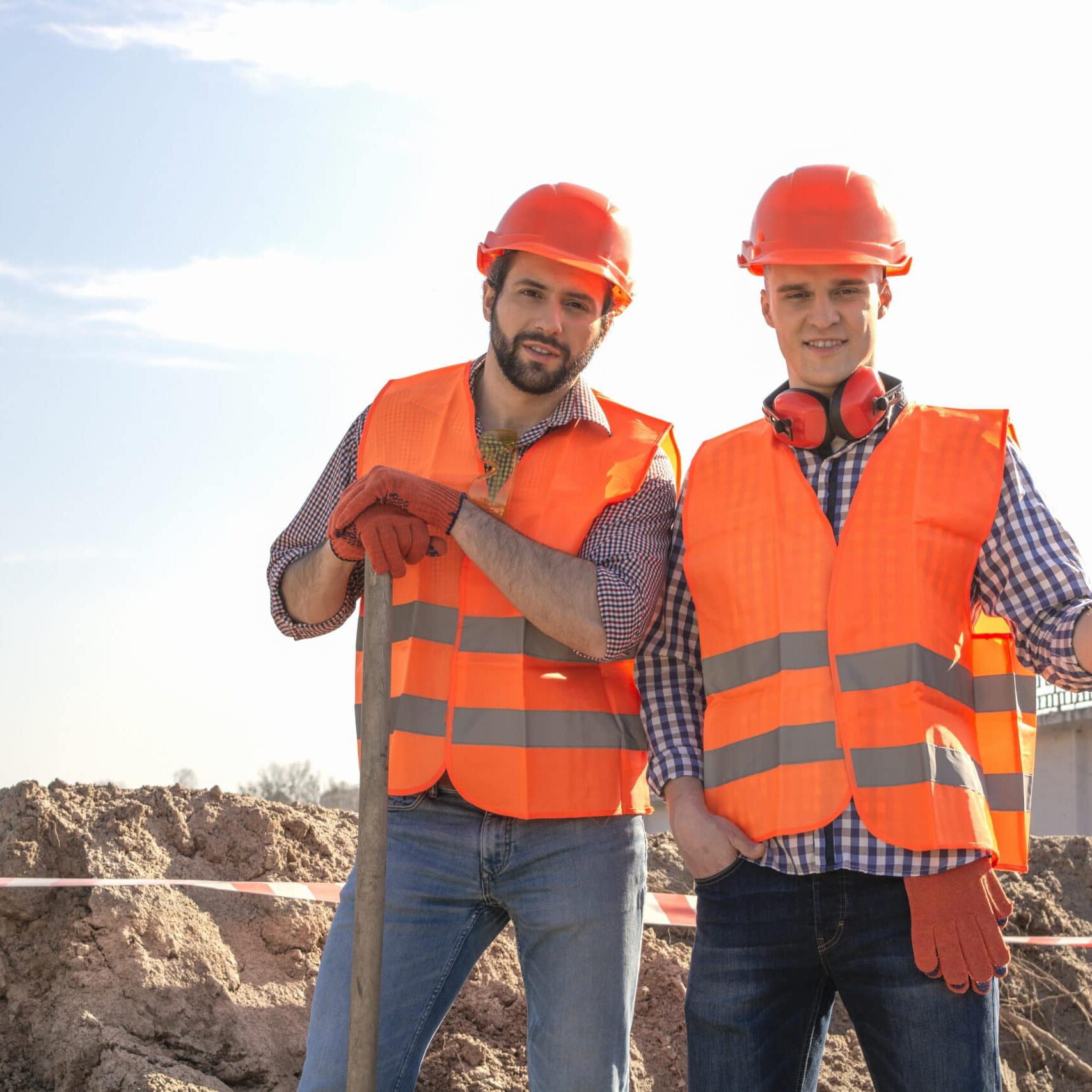 male workers engineers in helmets with the head, work, in the hands of a shovel